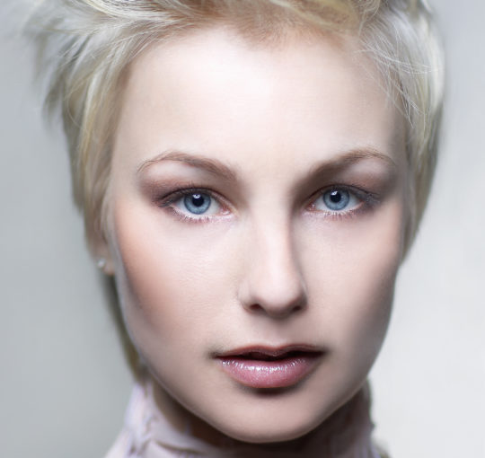 A short pixie hair cut left long on top to where different ways.  Set off by Platinum hair color.