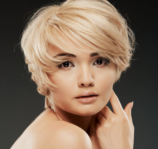 Very layered short hairstyle blowout is done with a large sweeping bang