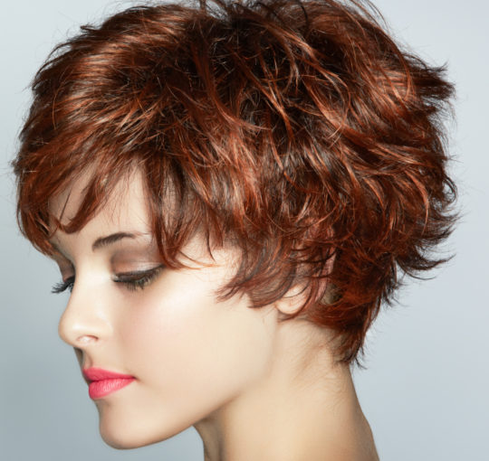 Short choppy shag brunette colored with red copper highlights throughout.